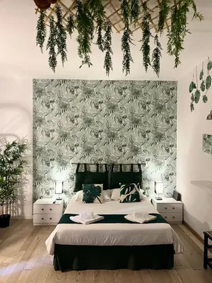 a bedroom with a bed with a floral wallpaper at L’oasi di Trastevere in Rome