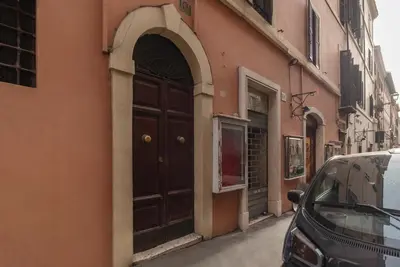 a door to a building with a car parked next to it at GuestHost - Piazza di Spagna Classy Apartment in Rome