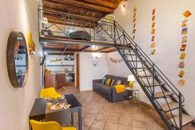 a living room with a spiral staircase in a loft at L'antico borgo di Trastevere II in Rome