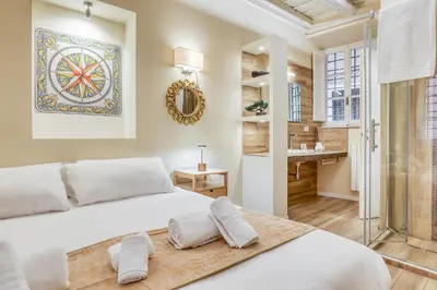 a bedroom with a large white bed and a bathroom at Easybnb - Domus Orbitelli in Rome