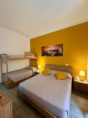 a bedroom with a large bed with a yellow curtain at Paradise Suite Roma centro in Rome