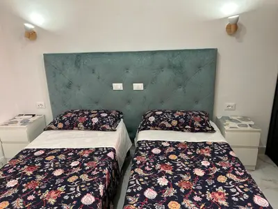 a bedroom with two beds and a green headboard at Guesthouse Dahlia Rossa in Rome