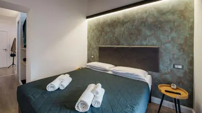 a bedroom with a green bed with white towels on it at Ripetta Boutique Suites in Rome