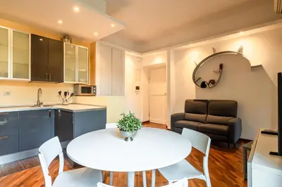 a kitchen and living room with a white table and chairs at Piazza del Popolo Home 2 camere in Rome