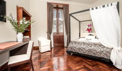 a bedroom with a bed and a desk with a mirror at Princess house Roma in Rome