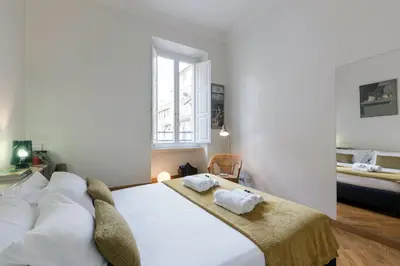 a bedroom with a large white bed and a window at Rome As You Feel - Two-Bedroom Apartment in Monti in Rome