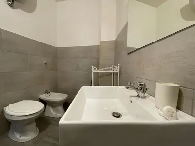a bathroom with a white sink and a toilet at Spacious and Bright in Rome