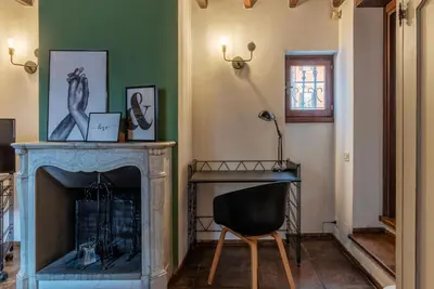 a living room with a fireplace and a chair at GuestHost - Cozy Trevi Romance in Rome