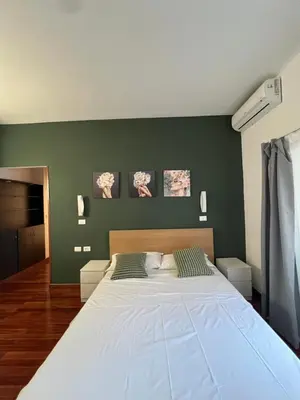 a large bed in a bedroom with green walls at Casa vacanza “Eden” in Rome