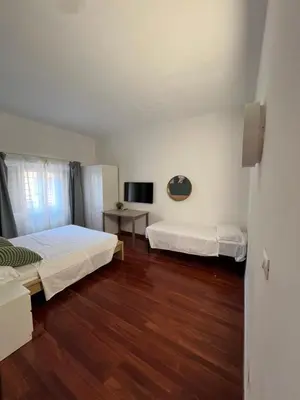 a bedroom with two beds and a wooden floor at Casa vacanza “Eden” in Rome