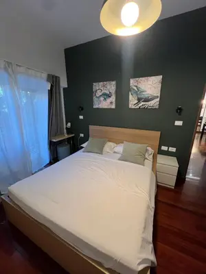 a bedroom with a large white bed with a black wall at Casa vacanza “Eden” in Rome