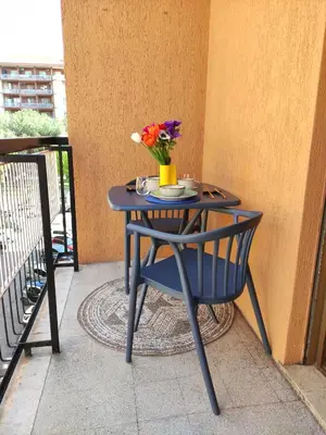 a blue table with a vase of flowers on a balcony at MT apartment in Rome