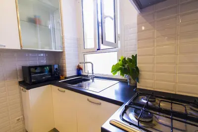 a small kitchen with a sink and a microwave at Colossehome - Dream House around the corner from Colosseum in Rome