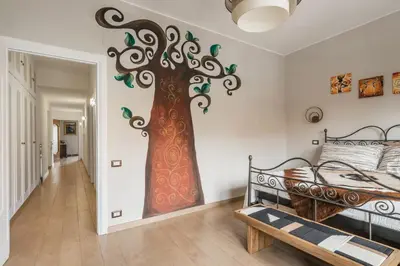 a bedroom with a tree mural on the wall at Dalia's Place in Rome