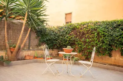 a table and two chairs sitting next to a fence at Maison Balduina in Rome