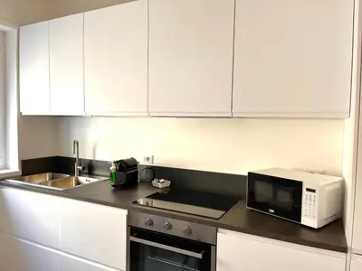 a kitchen with white cabinets and a microwave at Paula Petra Vatican Apartments in Rome
