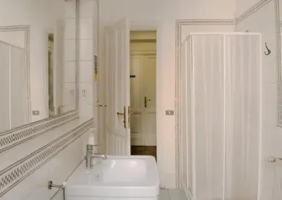 a white bathroom with a sink and a mirror at Minerva Rooms in Rome