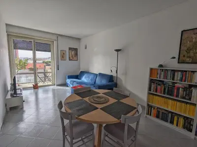 a living room with a table and a blue couch at SyrakaHost Intero appartamento in Rome
