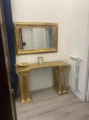 a gold table with a mirror on a wall at New opening Sweet Apartament Trastevere in Rome