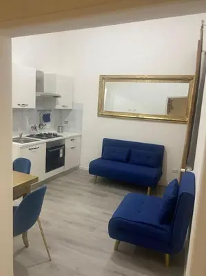 a living room with two blue chairs and a kitchen at New opening Sweet Apartament Trastevere in Rome