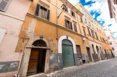 an old building with a green door on a street at Maison della Luce in Rome
