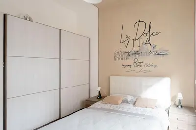 a bedroom with a white bed and a sign on the wall at Dolcevita San Lorenzo luxury in Rome