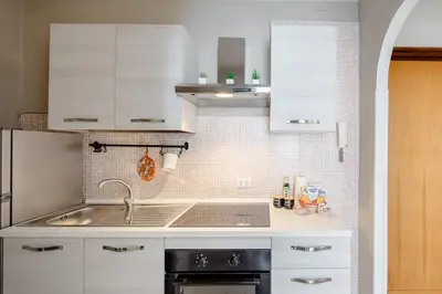 a kitchen with white cabinets and a sink at Dolcevita San Lorenzo luxury in Rome