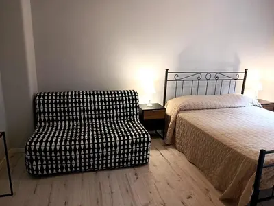 a bedroom with a bed and a chair next to it at Casa Paolina a Metro San Paolo in Rome