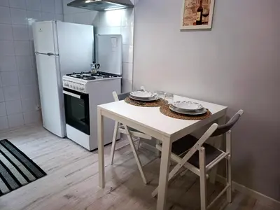 a small kitchen with a table and a refrigerator at Casa Paolina a Metro San Paolo in Rome