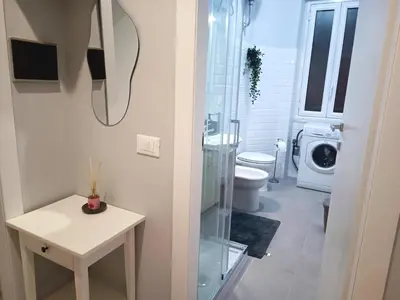 a bathroom with a toilet and a washing machine at Casa Paolina a Metro San Paolo in Rome