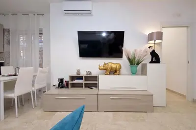 a living room with a tv on a white wall at Lovely apartment with terrace near the Vatican in Rome