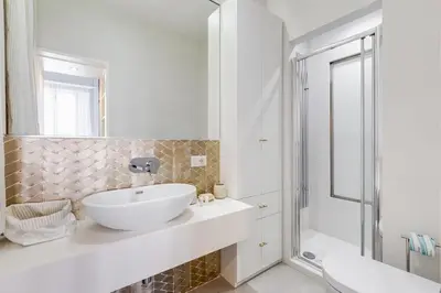 a white bathroom with a sink and a shower at CasaDoria51 in Rome