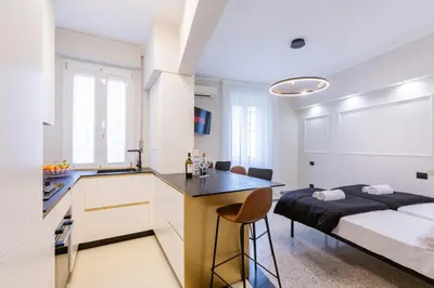 a bedroom with a bed and a kitchen with a desk at LUCIANO LUXURY APARTMENT in Rome