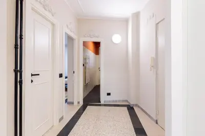 a hallway with white walls and a black and white tile floor at LUCIANO LUXURY APARTMENT in Rome