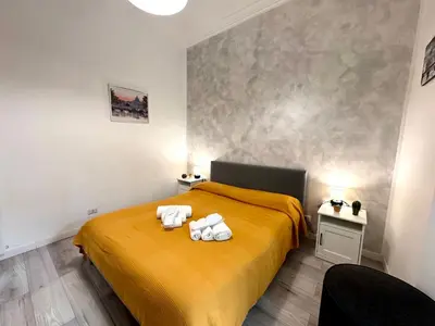 a bedroom with a yellow bed with towels on it at AmoR San Lorenzo in Rome