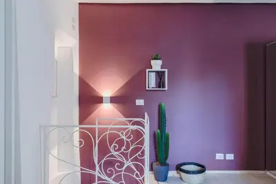 a room with a purple wall with a cactus at La Casetta a Monti in Rome