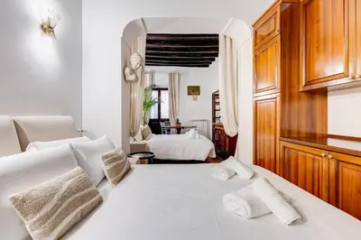 a white bedroom with two beds and a mirror at GIULIO CESARE DELUXE - Spanish Step RomeDreamHome in Rome