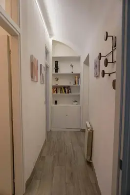 a hallway with white walls and wooden floors at Seminterrato al Pıgneto metro C in Rome