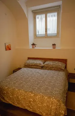a bedroom with a bed and a window at Seminterrato al Pıgneto metro C in Rome