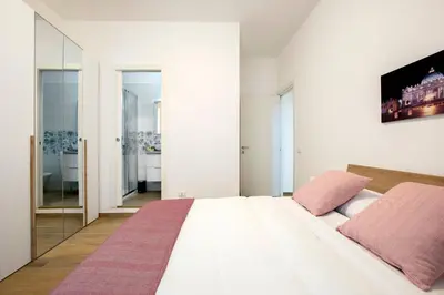 a bedroom with a large white bed with pink pillows at Domus Ascanio by the Vatican in Rome