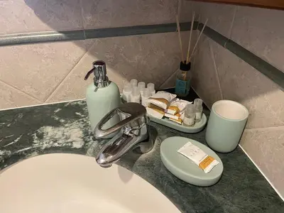 a bathroom sink with a soap dispenser and a bottle of soap at Sun's House in Rome