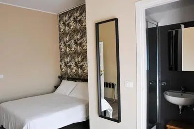 a bedroom with a bed and a mirror and a sink at Guest House Prime Palace in Rome