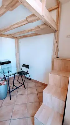 a room with stairs and a table and a desk at Attic Roof Oasi Vaticana in Rome