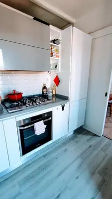 a kitchen with white cabinets and a stove top oven at Attic Roof Oasi Vaticana in Rome