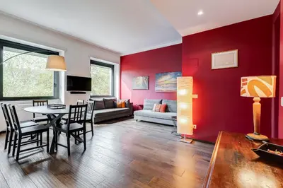 a living room with red walls and a table and chairs at Music Bridge Apartment in Rome
