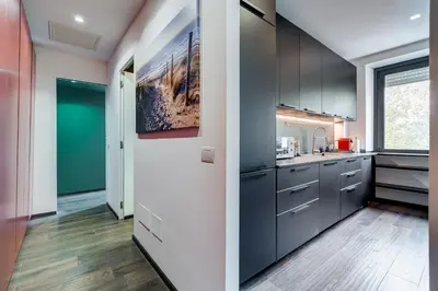 a kitchen with gray cabinets and a large window at Music Bridge Apartment in Rome