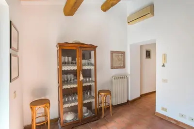 a room with a wooden cabinet and two stools at Antica Dimora al Vaticano in Rome
