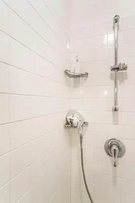 a shower with a hose in a white tiled bathroom at Antica Dimora al Vaticano in Rome