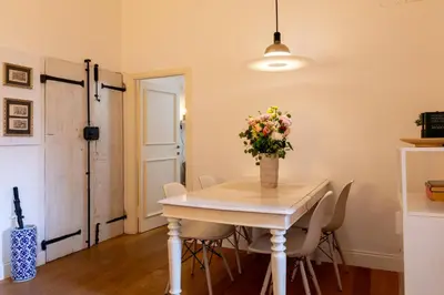 a dining room with a table and chairs with a vase of flowers at Casa Cecilia Roma in Rome