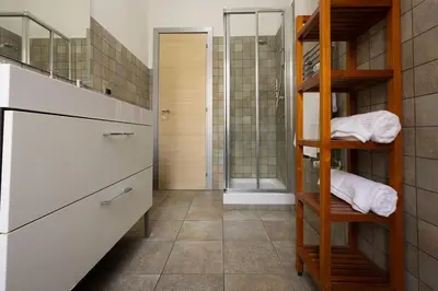 a bathroom with a shower and a sink and a shelf at MC Apartment San Giovanni in Rome